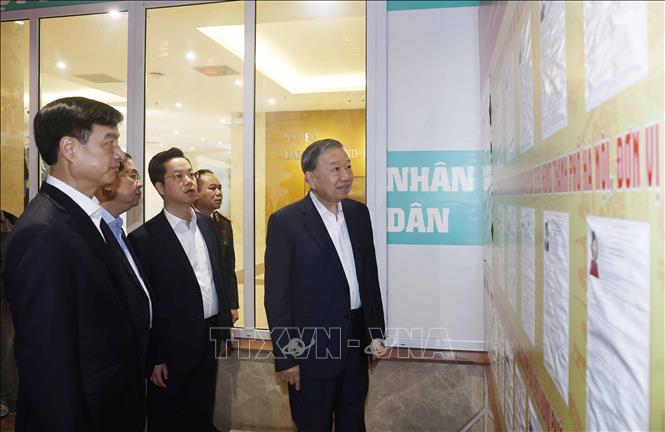 Tổng Bí thư Tô Lâm và các đại biểu tại nơi niêm yết danh sách trích ngang và tiểu sử tóm tắt ứng cử viên đại biểu Quốc hội khóa XVI tại trụ sở UBND phường Hoàn Kiếm. Ảnh: Thống Nhất – TTXVN