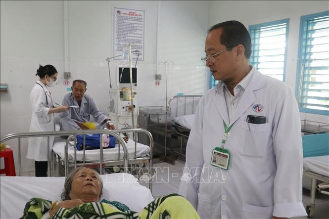 Bác sĩ chuyên khoa II Trần Văn Huyền, Phó Giám đốc Bệnh viện Đa khoa khu vực Cai Lậy thăm hỏi bệnh nhân đang điều trị. Ảnh: Công Trí-TTXVN
