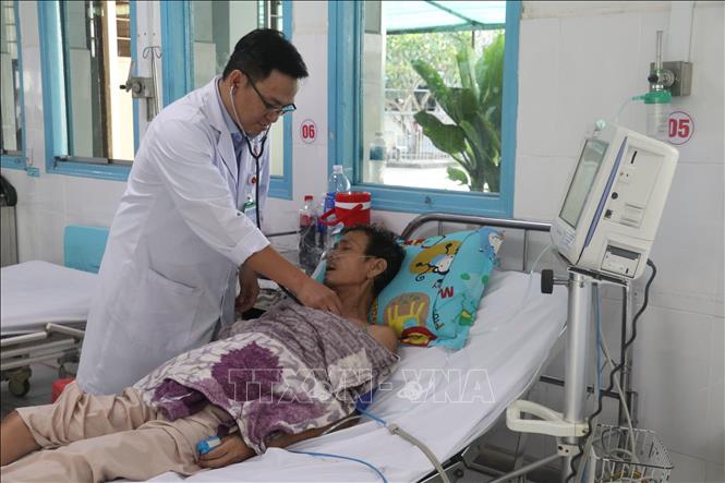 Bác sĩ Chuyên khoa I Đào Quang Vinh, Trưởng Khoa Hồi sức cấp cứu, Bệnh viện Đa khoa khu vực Cai Lậy, thăm khám cho bệnh nhân. Ảnh Công Trí-TTXVN