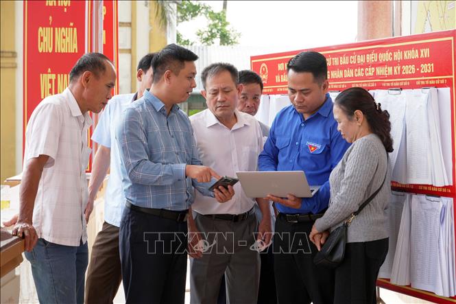 Cử tri phường Hà Huy Tập (tỉnh Hà Tĩnh) tìm hiểu thông tin về bầu cử thông qua các ứng dụng trên điện thoại thông minh. Ảnh: Hữu Quyết – TTXVN