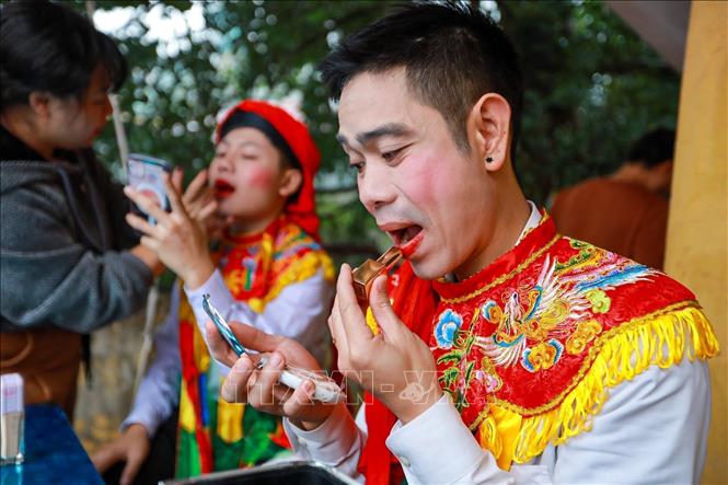 Men put on makeup before performing 