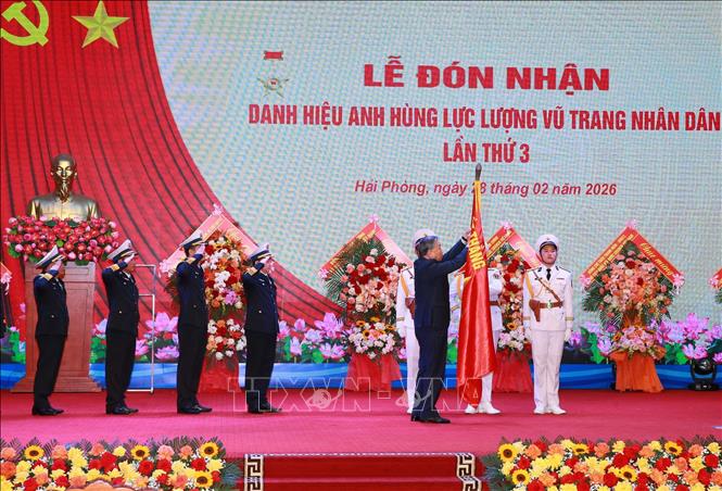 Tổng Bí thư Tô Lâm, Bí thư Quân ủy Trung gắn Huy hiệu Anh hùng LLVTND lên Quân kỳ Quyết thắng của Quân chủng Hải quân. Ảnh: Trọng Đức - TTXVN