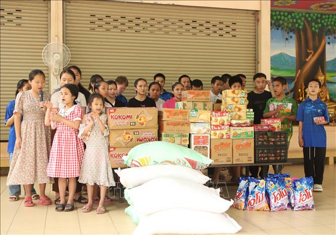 Mặc dù không thể nhìn rõ các phần quà, nhưng các học sinh khiếm thị đều cảm nhận được và thể hiện niềm vui. Ảnh: Xuân Tú - PV TTXVN tại Lào