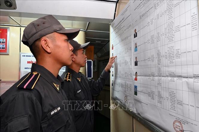 Cử tri tàu Cảnh sát biển 6008 tìm hiểu danh sách niêm yết các ứng cử viên. Ảnh: TTXVN phát 