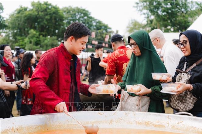 Rất đông người xếp hàng để được thưởng thức món Ketupat Cap Go Meh nấu trong chiếc chảo khổng lồ. Ảnh: Đỗ Quyên – PV TTXVN tại Indonesia