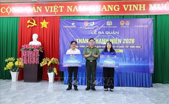 Thượng tá Phan Quốc Dũng, Phó Trưởng phòng Công tác chính trị Công an tỉnh An Giang trao bảng tượng trưng tặng 10 suất học bổng  và 300 phần quà “Tết chuyền tay” cho học sinh có hoàn cảnh khó khăn trên địa bàn xã Nhơn Hội. Ảnh: Công Mạo-TTXVN