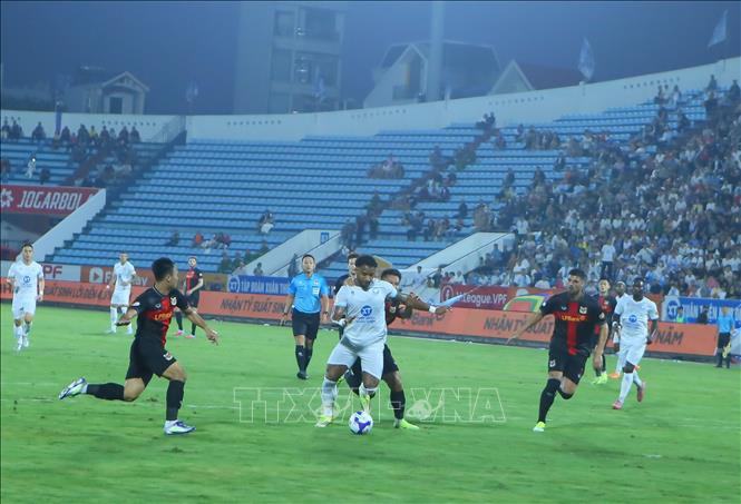 Tình huống tranh chấp bóng giữa các cầu thủ Thép Xanh Nam Định (áo trắng) và các cầu thủ Ninh Bình. Ảnh: Công Luật - TTXVN