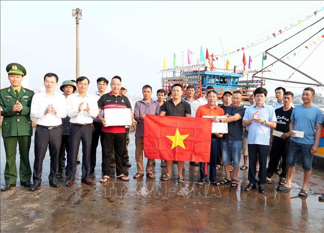 Phó Chủ tịch UBND tỉnh Quảng Trị Lê Văn Bảo tặng quà, cờ Tổ quốc động viên các ngư dân trong tỉnh sau những chuyến biển vươn khơi, đánh bắt đầu năm mới Bính Ngọ 2026. Ảnh: Tá Chuyên - TTXVN