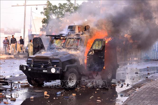 Xe cảnh sát bị đốt cháy trong cuộc đụng độ bên ngoài Lãnh sự quán Mỹ tại Karachi, Pakistan, ngày 1/3/2026. Ảnh: THX/TTXVN