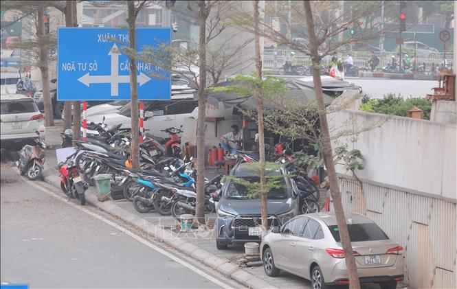 Nhiều ôtô, xe máy đỗ kín lề đường, thậm chí tràn xuống lòng đường dưới gầm nhà ga Cầu Giấy. Ảnh: Phan Phương – TTXVN