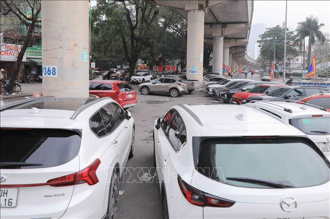 Bãi xe trước Đền Voi Phục, nhiều ô tô, xe máy đỗ kín cả chân cầu, gây mất mỹ quan và tiềm ẩn nguy cơ cháy nổ. Ảnh: Phan Phương – TTXVN