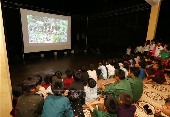 Nhà Văn hóa BĐBP phối hợp với Đồn Biên phòng Nậm Chảy (huyện Mường Khương, tỉnh Lào Cai) tổ chức thông báo cho nhân dân, bộ đội, học sinh ăn cơm sớm, dựng rạp, chiếu phim phục vụ khu vực biên giới. Ảnh: Anh Tuấn - TTXVN