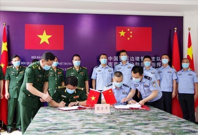 Đoàn đại biểu Chi đội quản lý biên giới Phổ Nhĩ (Trung Quốc) và Đoàn đại biểu Bộ Chỉ huy Bộ đội Biên phòng tỉnh Điện Biên (Việt Nam) ký Biên bản ghi nhớ. Ảnh: Xuân Tiến - TTXVN