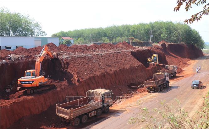 Sau khi báo chí phản ánh, chiều 2/3, một số phương tiện cơ giới đã bắt đầu hạ taluy khu vực nhà dân bị “treo cao”. Ảnh: Đậu Tất Thành – TTXVN
