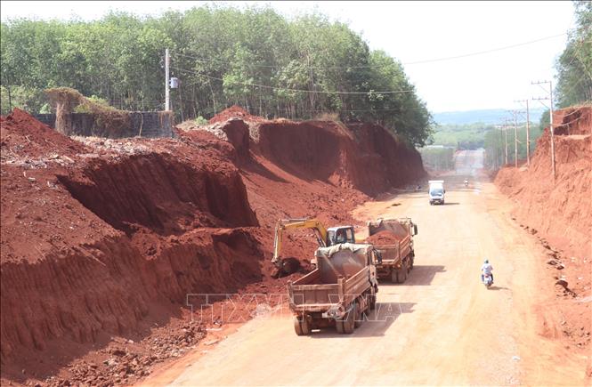 Sau khi báo chí phản ánh, chiều 2/3, một số phương tiện cơ giới đã bắt đầu hạ taluy khu vực nhà dân bị “treo cao”. Ảnh: Đậu Tất Thành – TTXVN
