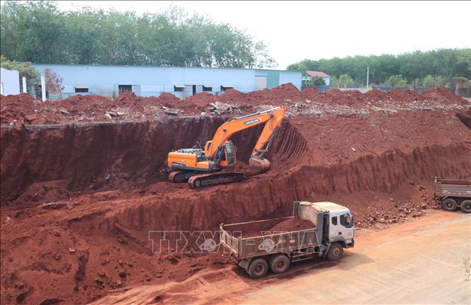 Sau khi báo chí phản ánh, chiều 2/3, một số phương tiện cơ giới đã bắt đầu hạ taluy khu vực nhà dân bị “treo cao”. Ảnh: Đậu Tất Thành – TTXVN
