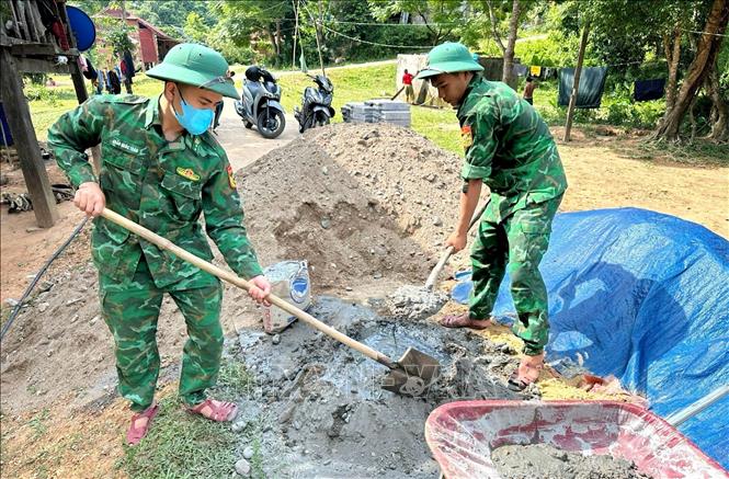Cán bộ, chiến sĩ Đồn Biên phòng Làng Mô trực tiếp tham gia ngày công giúp đỡ bà con biên giới. Ảnh: TTXVN phát