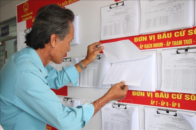 Người dân xã Khánh Bình theo dõi danh sách cử tri, chuẩn bị cho bầu cử. Ảnh: Chanh Đa-TTXVN 