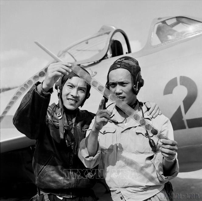Phi côngTrần Hanh và Phạm Ngọc Lan (phải), 2 phi công xuất sắc của Không quân Việt Nam, từng hạ nhiều máy bay Mỹ đang kiểm tra kết quả chiến đấu ghi trên phim sau khi hoàn thành nhiệm vụ chiến đấu trở về. Ảnh: Đoàn Tý – TTXVN