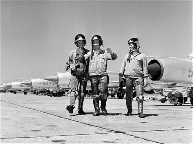 Hai Anh hùng không quân Nguyễn Văn Cốc (phải) và Phạm Thanh Ngân (giữa) cùng đồng đội trao đổi kinh nghiệm sau chuyến bay (năm 1969). Ảnh: Lương Nghĩa Dũng - TTXVN