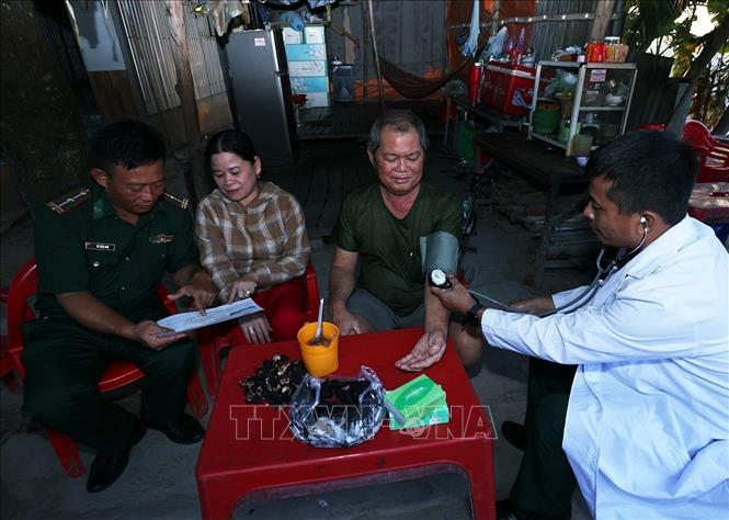 Bộ đội Biên phòng Đồn Cửa khẩu Quốc tế Dinh Bà thăm, khám bệnh và tuyên truyền bảo vệ an ninh Tổ quốc ở hộ gia đình ông Nguyễn Hữu Long, xã Tân Hộ Cơ, tỉnh Đồng Tháp. Ảnh: Vũ Sinh – TTXVN 