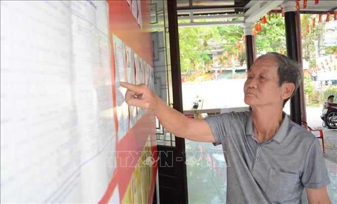 Cử tri đến xem danh sách đại biểu tại khu vực bỏ phiếu số 11 thành phố Huế. Ảnh: Văn Dũng-TTXVN