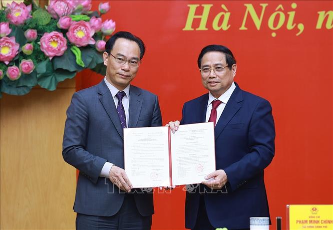 Thủ tướng Phạm Minh Chính trao Quyết định của Thủ tướng Chính phủ về việc điều động đồng chí Hoàng Minh Sơn, Giám đốc Đại học Quốc gia Hà Nội về công tác tại Bộ Giáo dục và Đào tạo, giao Quyền Bộ trưởng Bộ Giáo dục và Đào tạo. Ảnh: Dương Giang-TTXVN 