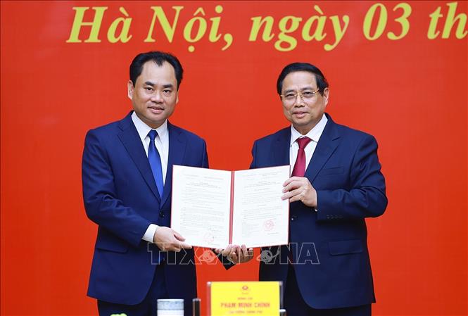 Thủ tướng Phạm Minh Chính trao Quyết định của Thủ tướng Chính phủ về việc tiếp nhận, bổ nhiệm đồng chí Trịnh Việt Hùng giữ chức Thứ trưởng Thường trực Bộ Nông nghiệp và Môi trường. Ảnh: Dương Giang-TTXVN 
