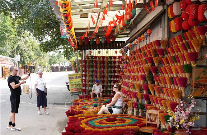 Foreign visitors take photos at Thuy Xuan incense making village. VNA Photo: Nguyên Lý