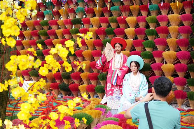 Young girls taking photos at Thuy Xuan incense making village. VNA Photo: Nguyên Lý
