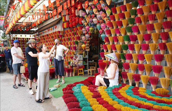 Foreign visitors take photos at Thuy Xuan incense making village. VNA Photo: Nguyên Lý