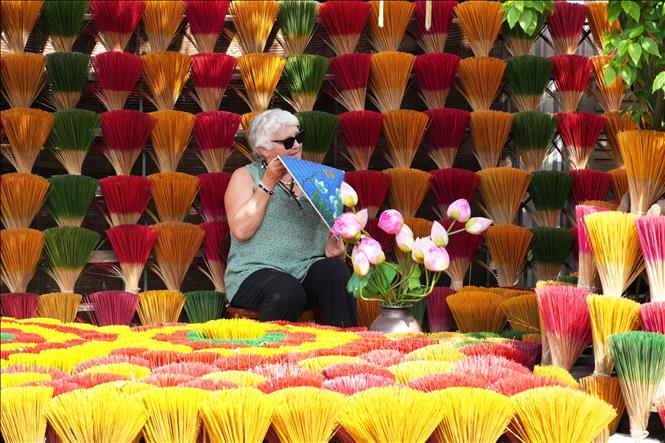 Foreign visitors take photos at Thuy Xuan incense making village. VNA Photo: Nguyên Lý
