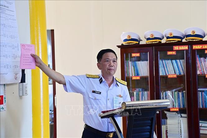 Đại tá Lê Hồng Quang, Tổ trưởng Tổ bầu cử sớm đi trên tàu Trường Sa 04, hướng dẫn thể lệ bầu cử. Ảnh: TTXVN phát  