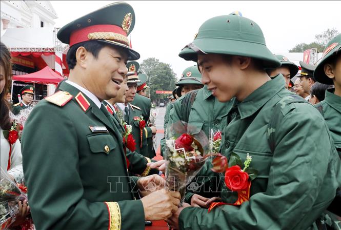 Đại tướng Nguyễn Tân Cương tặng hoa động viên các tân binh lên đường nhập ngũ. Ảnh: Thái Thuần - TTXVN