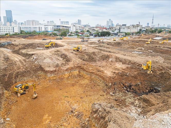 Đơn vị thi công hiện đang huy động tối đa máy xúc và xe tải để đẩy nhanh việc san lấp mặt bằng và đào lòng hồ. Ảnh: Lê Đông - TTXVN