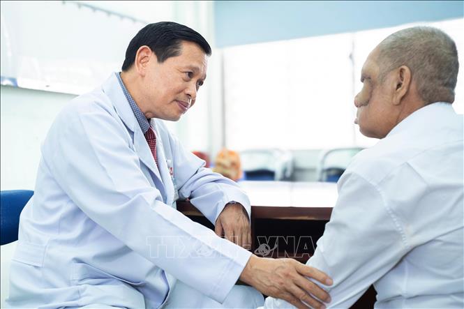 Bác sĩ Hoàng Bá Dũng, Trưởng Khoa Tai Mũi Họng, Bệnh viện Chợ Rẫy khám cho bệnh nhân trong ngày tái khám. Ảnh: TTXVN phát