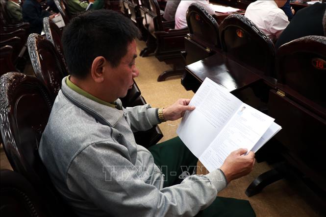 Cử tri xã Ý Yên (Ninh Bình) nghiên cứu tiểu sử của các ứng viên. Ảnh: Nguyễn Lành - TTXVN 