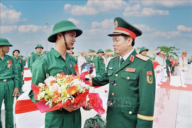 Thượng tướng Đỗ Xuân Tụng, Ủy viên Trung ương Đảng, Phó Chủ nhiệm Tổng cục Chính trị QĐND Việt Nam, tặng hoa, động viên thanh niên nhập ngũ tại điểm giao nhận quân số 3, Ban chỉ huy Phòng thủ khu vực 2, phường Nhị Quý, tỉnh Đồng Tháp. Ảnh: TTXVN phát