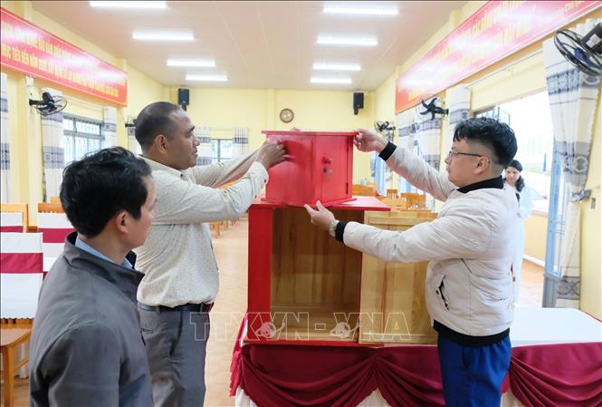 Đại diện chính quyền xã Lạc Dương kiểm tra công tác chuẩn bị cở sở vật chất cho ngày bầu cử tại khu vực bỏ phiếu số 4. Ảnh: Nguyễn Dũng – TTXVN 
