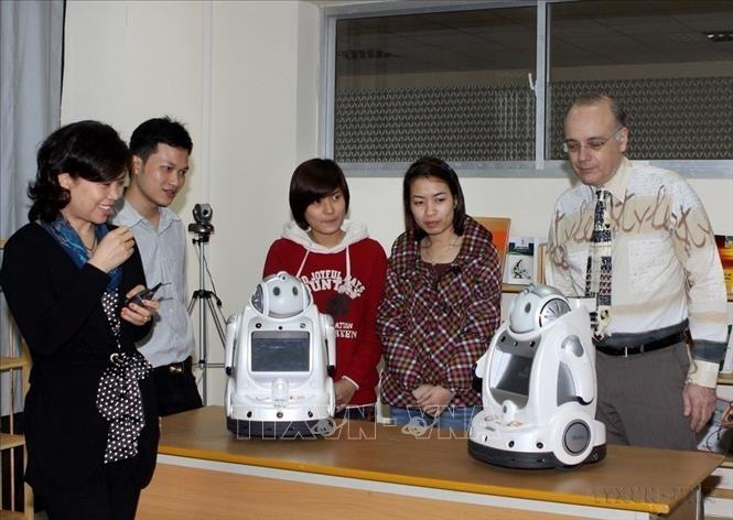 Giáo sư Hải Yến - Nữ Giáo sư trẻ nhất Việt Nam năm 2011 đang điều khiển cặp Rô-bôt song sinh Mây và Melis làm một số động tác đơn giản. Chị là chủ nhiệm đề tài nghiên cứu, chế tạo những ro-bot này (2011). Ảnh: Thái Bình - TTXVN