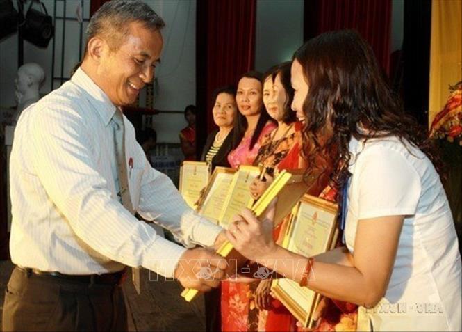 Chủ tịch Tổng liên đoàn Lao động Việt Nam Đặng Ngọc Tùng trao tặng bằng khen của Tổng Liên đoàn cho đại diện các tập thể nữ công nhân, người lao động của Tập đoàn Dệt may Việt Nam (VINATEX) có thành tích xuất sắc trong phong trào 