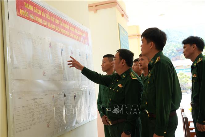 Lieutenant Colonel Tran Tri Tai, Political Commissar, and soldiers of the Cu Lao Cham Border Post in Tan Hiep commune review the list of candidates for the 16th National Assembly and People’s Councils at all levels for the 2026–2031 term. Photo: Do Truong – VNA