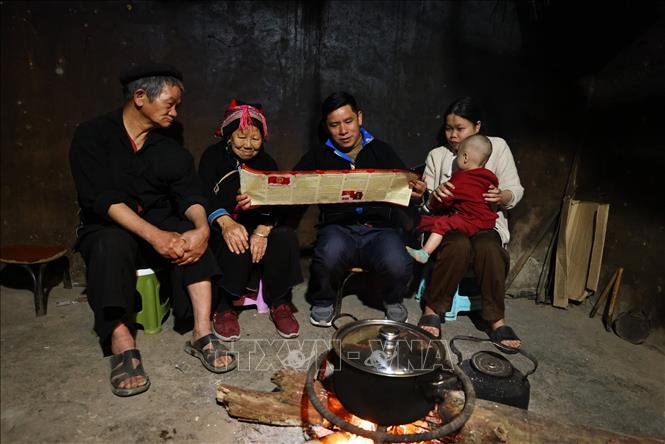 Cán bộ tuyên truyền bầu cử tại nhà dân ở thôn Nặm Đăm, xã Quản Bạ. Ảnh: Minh Đức – TTXVN