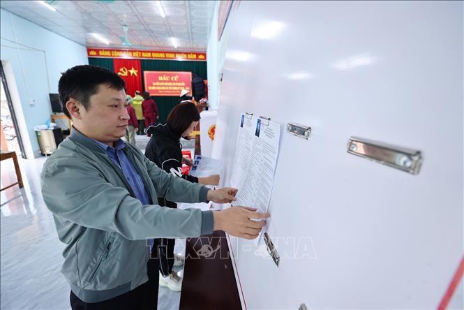 Dán danh sách ứng cử viên, trang trí hội trường, sắp xếp bàn ghế tại nhà văn hóa thôn Nà Khoang 1, xã Quản Bạ. Ảnh: Minh Đức – TTXVN