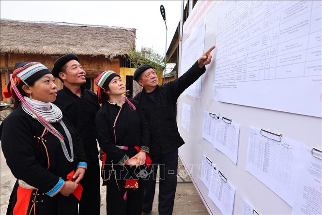 Cử tri xem danh sách đại biểu ứng cử được niêm yết công khai tại nhà văn hóa thôn Nặm Đăm, xã Quản Bạ. Ảnh: Minh Đức – TTXVN