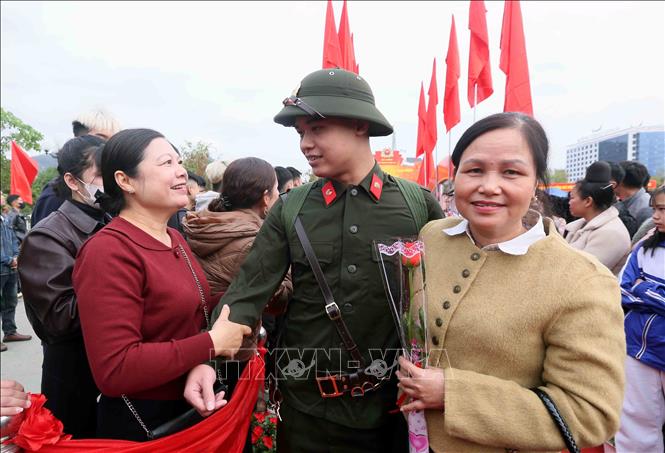 Thân nhân đến tặng hoa và đưa tiễn công dân lên đường thực hiện nghĩa vụ Công an nhân dân. Ảnh: Quang Quyết - TTXVN