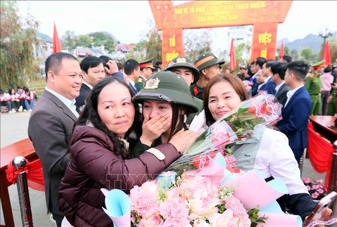 Thân nhân đến tặng hoa và đưa tiễn công dân nữ lên đường thực hiện nghĩa vụ Công an nhân dân. Ảnh: Quang Quyết - TTXVN