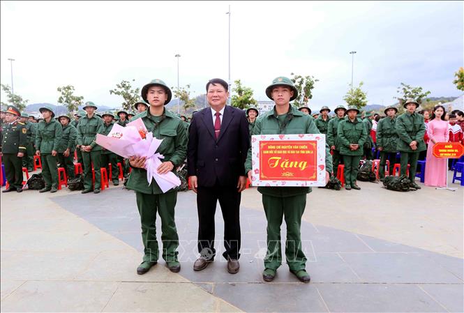 Phó Bí thư Thường trực Tỉnh ủy, Chủ tịch HĐND tỉnh Sơn La Lò Minh Hùng tặng hoa, quà chúc mừng các thanh niên lên đường nhập ngũ năm 2026. Ảnh: Quang Quyết - TTXVN