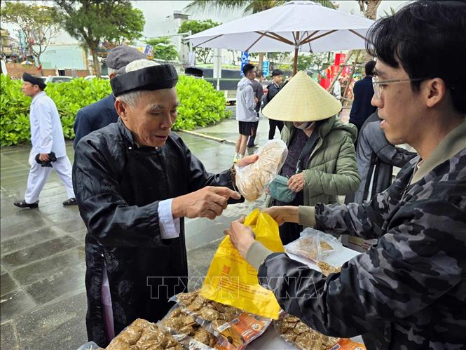 Người dân mua các sản phẩm thủy hải sản của ngư dân bày bán tại Lễ hội Cầu. Ảnh: Trần Lê Lâm - TTXVN