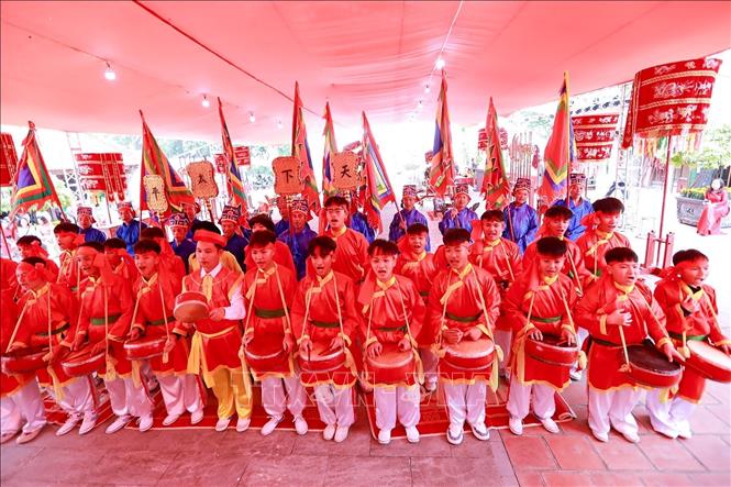 Các thiếu niên trong làng trình diễn nhịp nhàng xếp thành bốn chữ “Thiên - Hạ - Thái - Bình” để dâng lên Đức Thánh, đồng thời gửi gắm ước vọng về một đất nước thịnh vượng, xã hội an hòa, đời sống nhân dân ấm no, hạnh phúc. Ảnh: Khánh Hoà - TTXVN